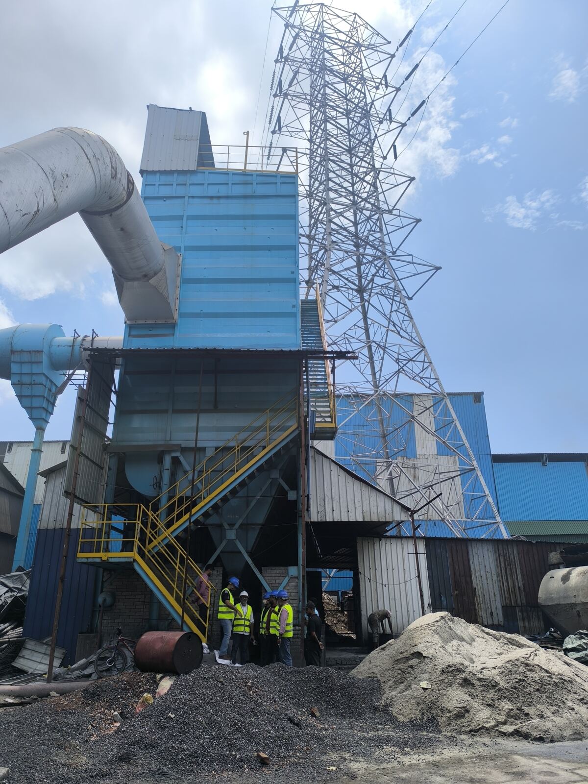 Completed bag house and ducting beside a transmission tower