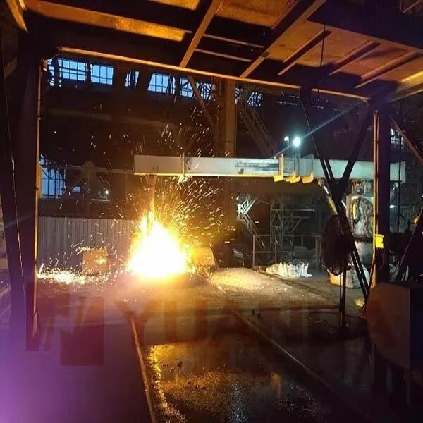Scrap picking arm in operation under the furnace hood